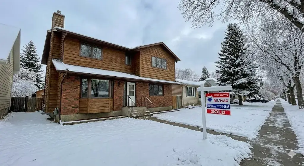 Picture of house for sale by Re/Max in the winter - Brandon MB